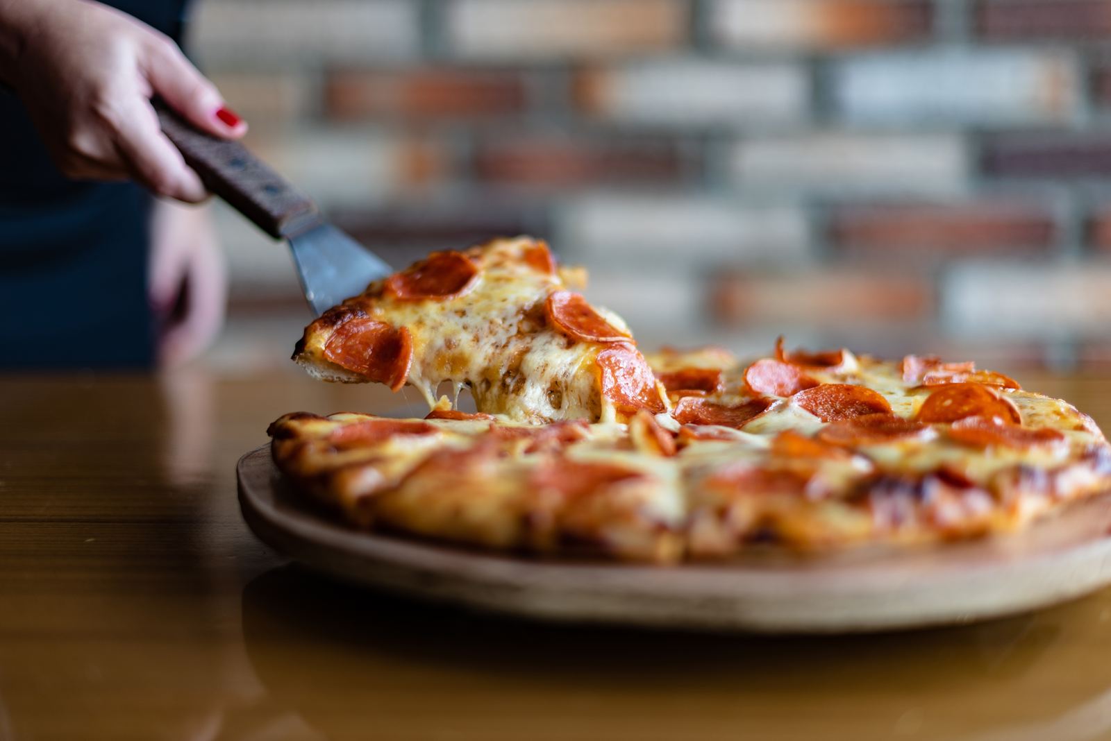 Lifting a slice from a fresh pizza
